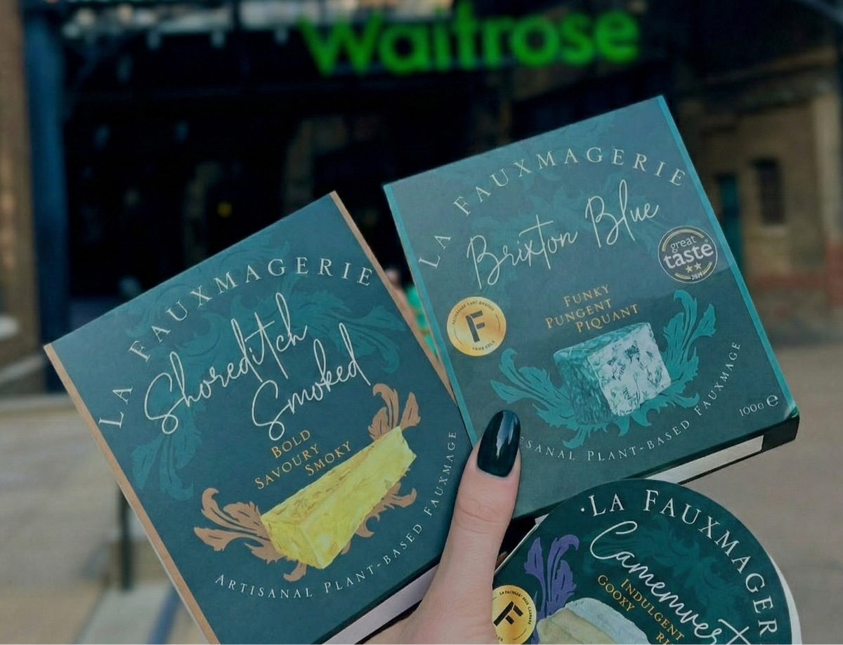 Three packages of 'La Fauxmagerie' cheese in front of a Waitrose store.
