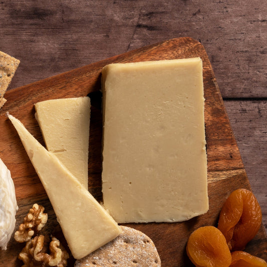 camden cultured truffle with crackers, dried fruits, and pretzels on a wooden board